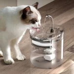 Katzify Katzen-Trinkbrunnen 'AquaFlow' in transparent mit Pumpe. Katze trinkt frisches gefiltertes Wasser aus einem Trinkbrunnen